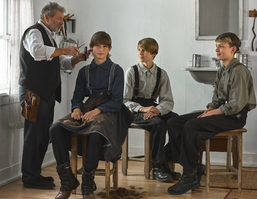 The settlement barber trimming the hair of young apprentices